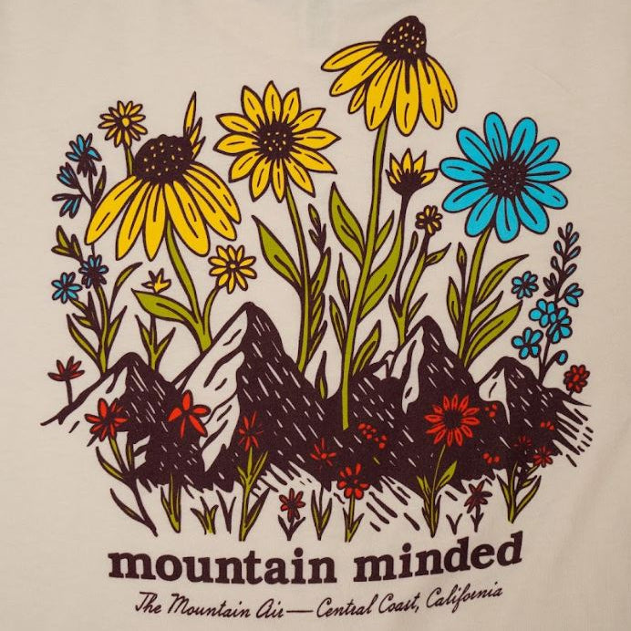 T-shirt design with flowers and mountains and 'mountain minded' text on a beige background